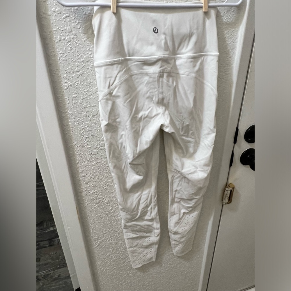 White 7/8 length lululemons with slight pink stain on leg.